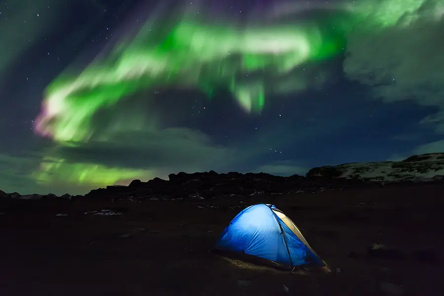 Zelt im Winter unter Polarlichtern