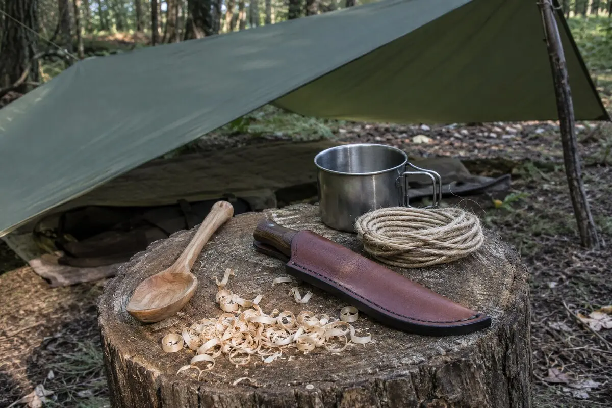 Geschnitzter Holzlöffel und verpacktes Bushcraft-Messer